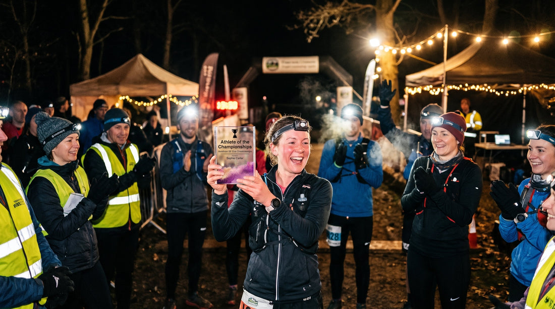 Five runners wearing head torches on an autumn woodland trail at dusk, passing glowing carved pumpkins during a Halloween night run.