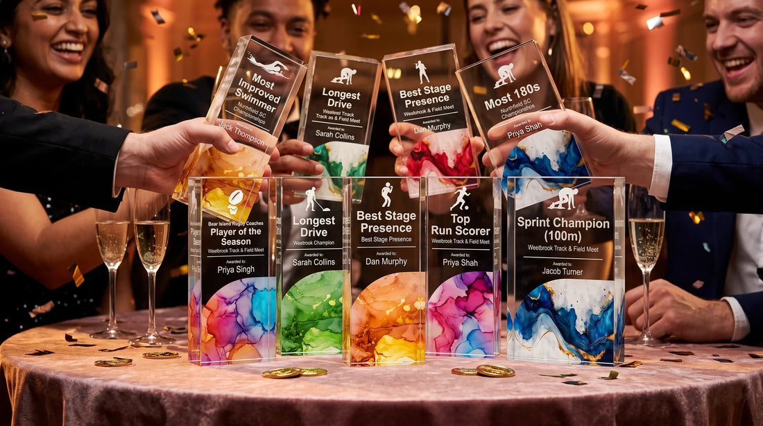 End-of-season sports and achievement awards dinner party showcasing personalized recognition plaques and trophies arranged on a tablecloth with champagne flutes while guests celebrate victory under warm indoor lighting.