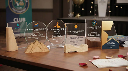 Collection of personalised glass and acrylic trophies on a table at a UK sports presentation night, including Player of the Year, Sportsmanship and Leadership awards