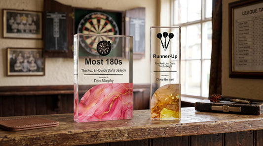 Custom pub darts trophies displayed on a wooden table for a darts competition