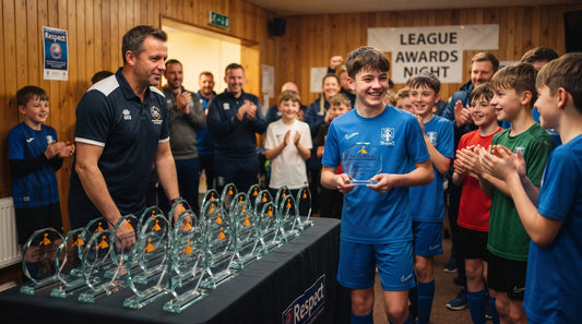 Player holding a personalised trophy during a UK sports league awards celebration with matching trophies prepared for other winners