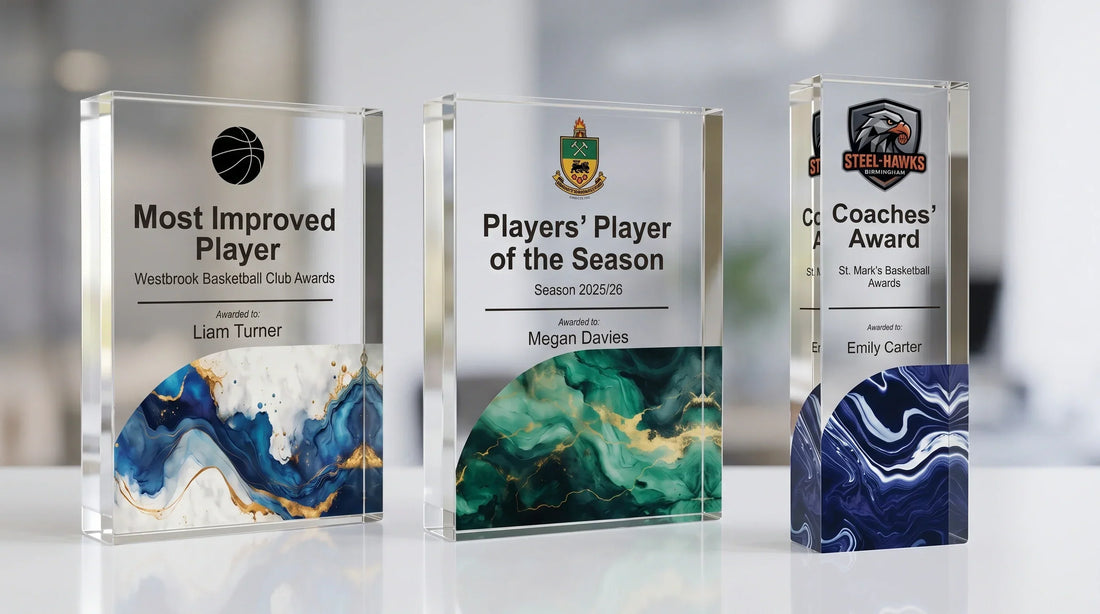 Three custom engraved glass sports trophies and crystal awards displaying "Most Improved Player," "Players' Player of the Season," and "Coaches' Award" with personalized names and marble-accented bases.