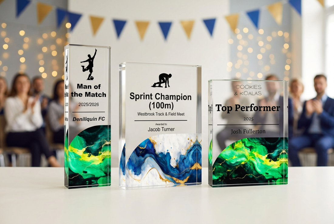 Personalised acrylic football, athletics and employee recognition trophies on an awards table with applauding guests and blue and gold bunting