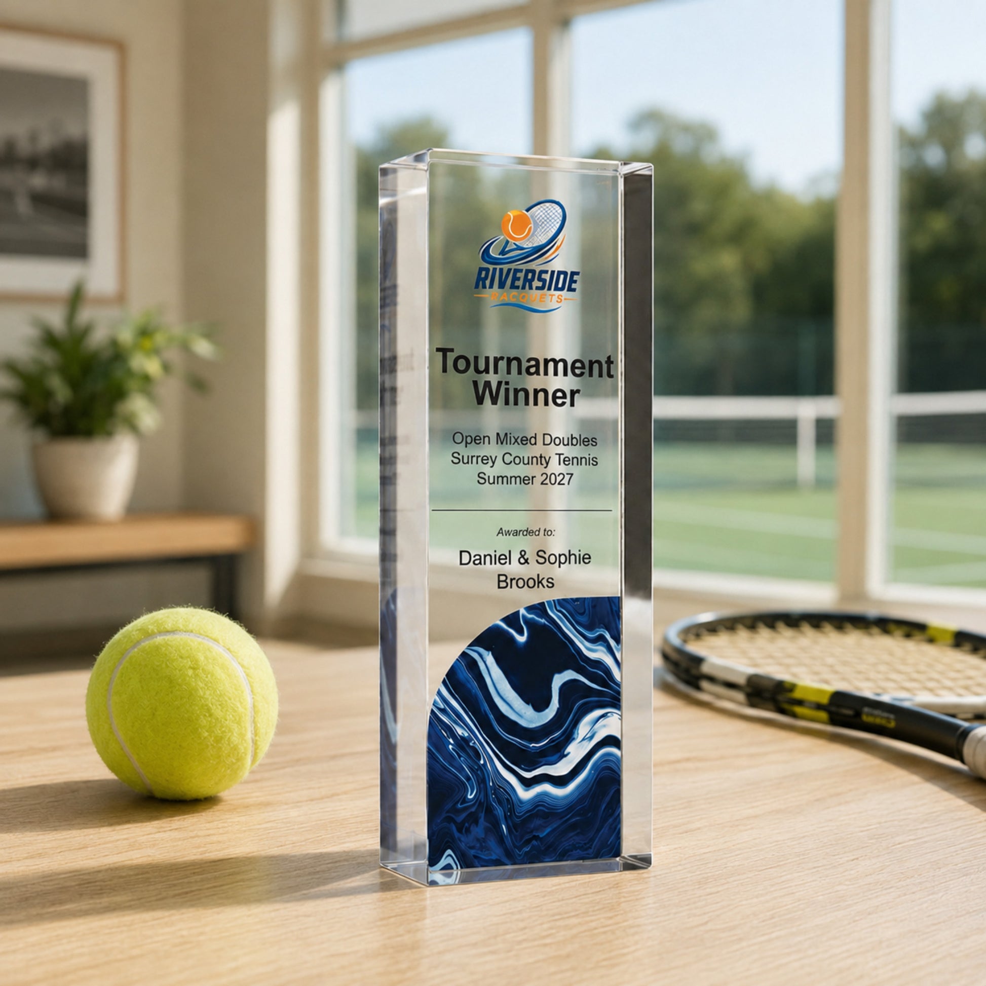 Tournament Winner tennis trophy with a club crest, beside a racket and ball