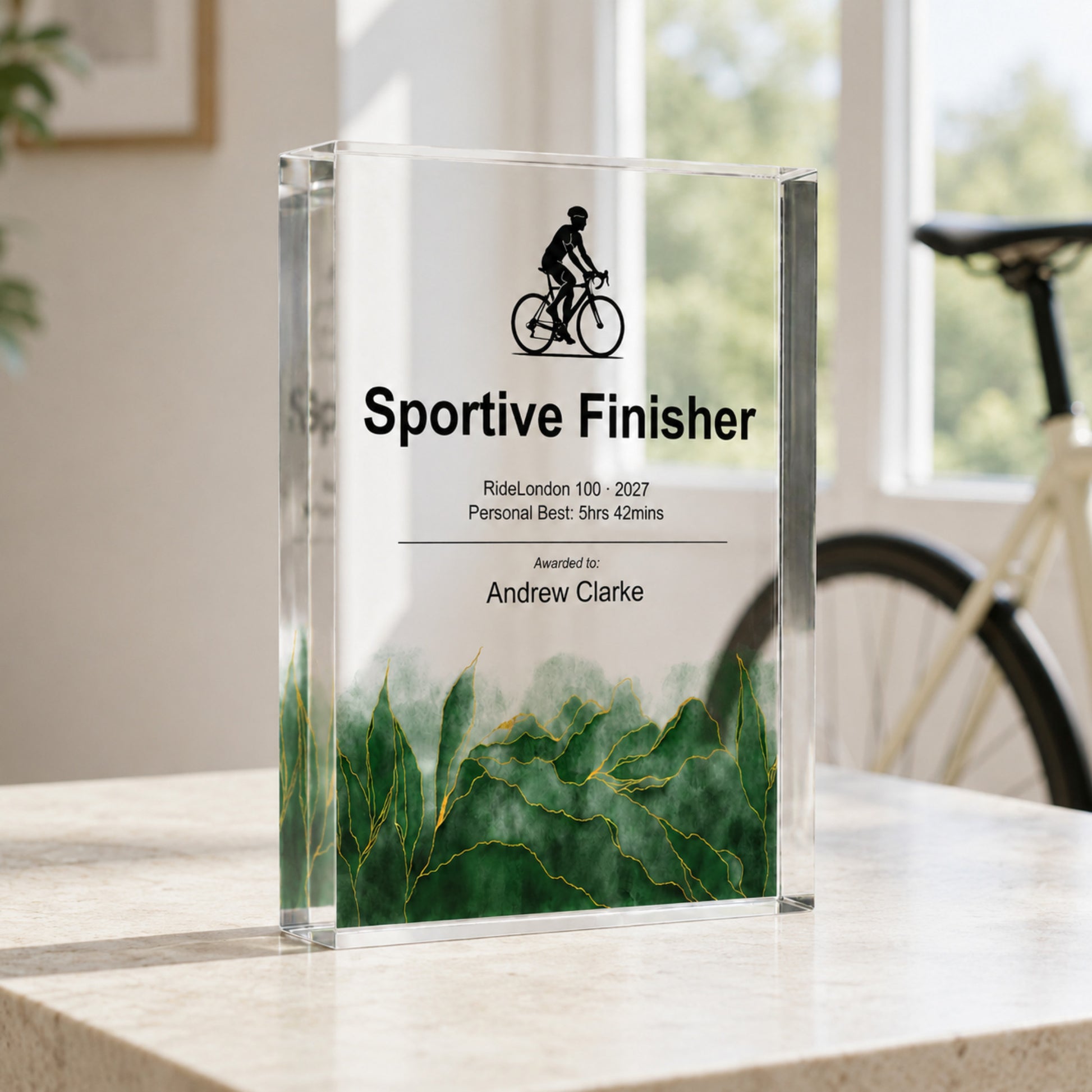 Sportive Finisher acrylic award for a cycling club prize-giving, beside a road bike